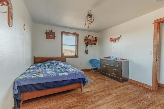 bedroom with light wood-type flooring and baseboards