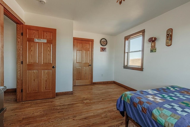 bedroom with baseboards and wood finished floors