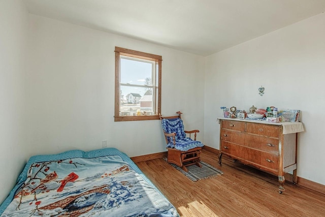 bedroom with light wood finished floors and baseboards