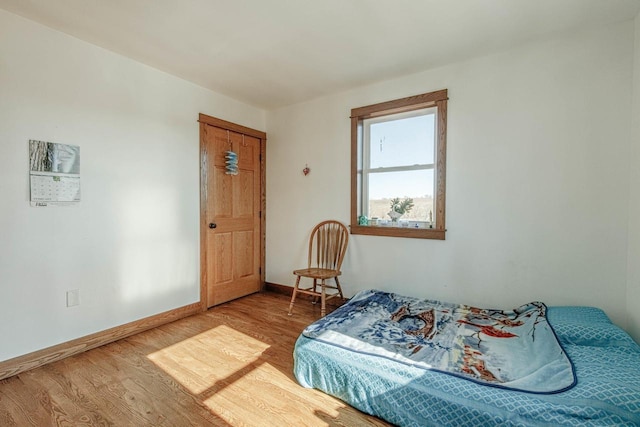 bedroom with wood finished floors and baseboards