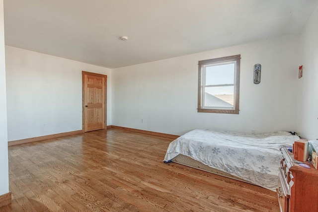 bedroom with light wood finished floors and baseboards