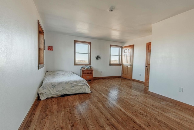 bedroom with baseboards and wood finished floors