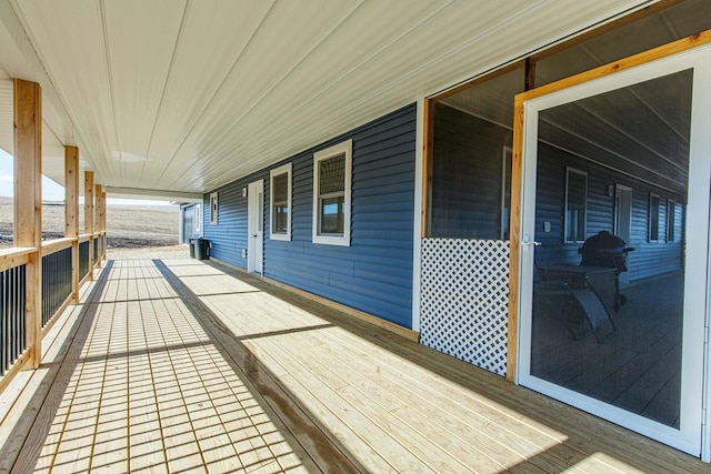 wooden terrace featuring covered porch and area for grilling