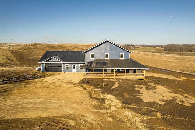 view of front facade featuring driveway, an attached garage, and metal roof