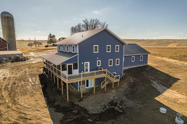 back of house with metal roof and a wooden deck