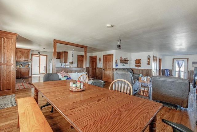 dining space featuring light wood-style floors and wainscoting