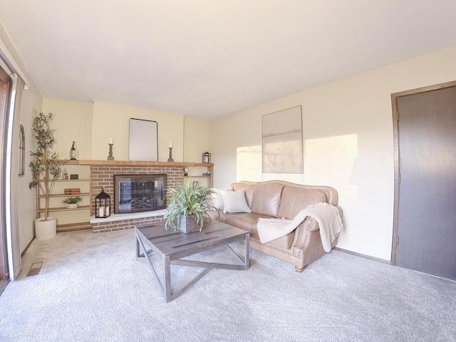 living area with a brick fireplace and carpet flooring