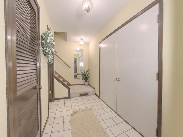 interior space featuring light tile patterned floors, stairs, visible vents, and arched walkways