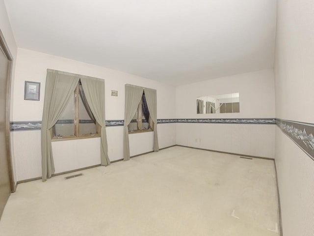 spare room with visible vents and light carpet