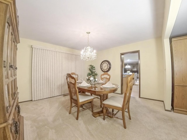 dining area with an inviting chandelier, baseboards, and light colored carpet