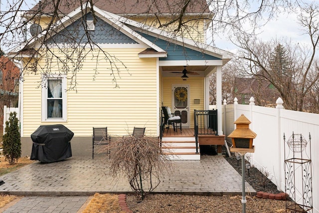 back of house with a ceiling fan, a patio area, fence, and a chimney