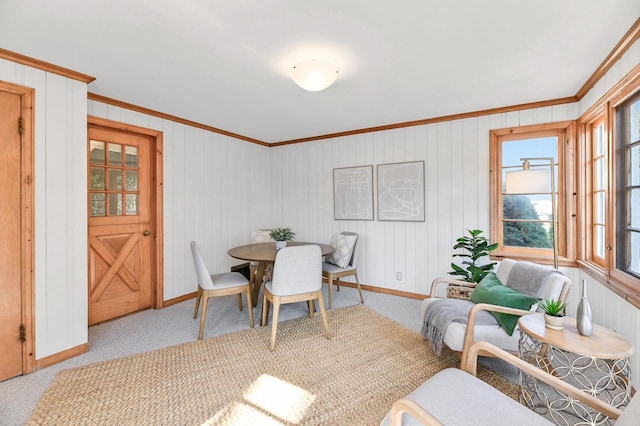 carpeted dining space featuring baseboards and ornamental molding