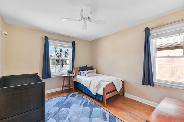 bedroom with baseboards, wood finished floors, and a ceiling fan