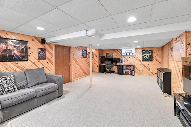 living room with carpet, recessed lighting, and wood walls