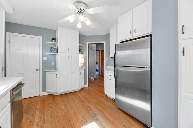 kitchen featuring light wood-type flooring, light countertops, appliances with stainless steel finishes, white cabinets, and open shelves