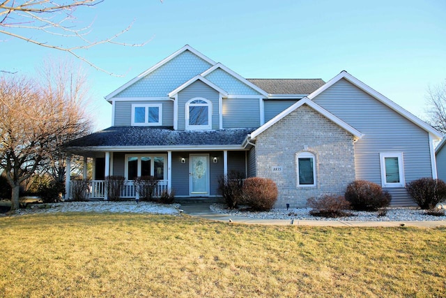 view of front facade featuring a porch, brick siding, and a front lawn