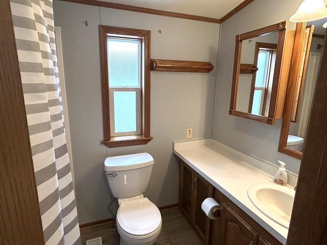 bathroom featuring crown molding, toilet, vanity, wood finished floors, and baseboards