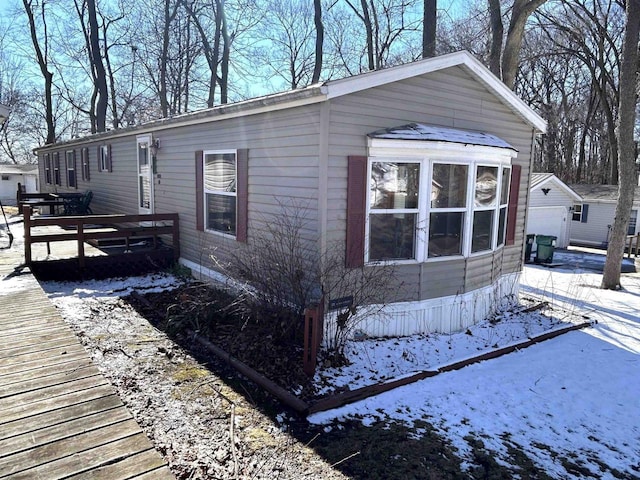 view of snow covered exterior featuring a garage and driveway