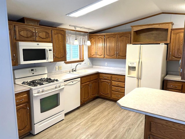 kitchen featuring lofted ceiling, white appliances, a sink, light wood-type flooring, and brown cabinets