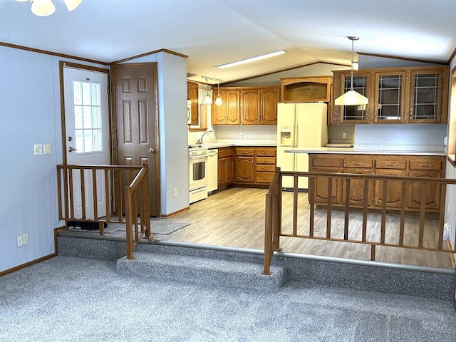 kitchen with lofted ceiling, white appliances, hanging light fixtures, brown cabinets, and glass insert cabinets