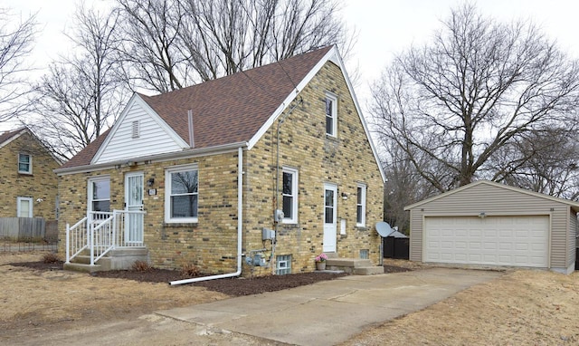 view of front facade featuring brick siding, a shingled roof, an outdoor structure, and a detached garage