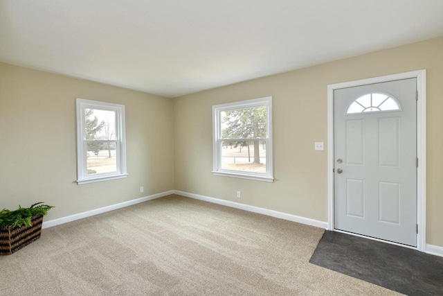 entryway featuring carpet floors, plenty of natural light, and baseboards