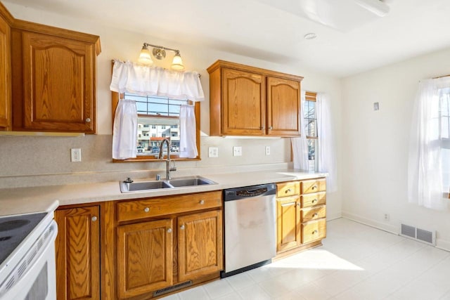 kitchen featuring a sink, visible vents, brown cabinets, and dishwasher