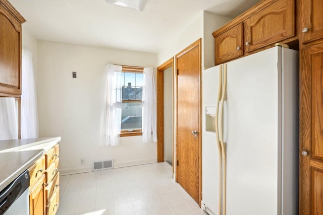 kitchen with visible vents, light floors, dishwasher, white refrigerator with ice dispenser, and brown cabinetry