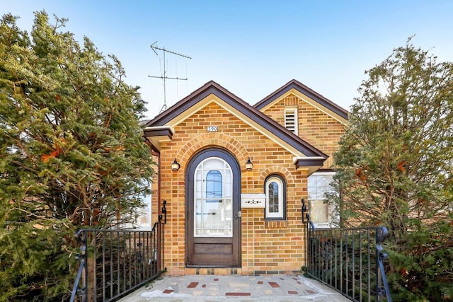 property entrance featuring brick siding and fence