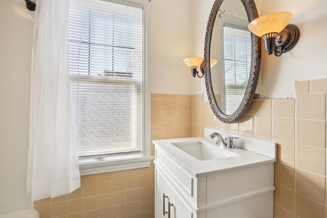 bathroom featuring a wealth of natural light, tile walls, and vanity