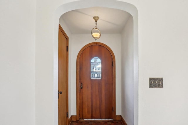 entryway featuring baseboards and arched walkways