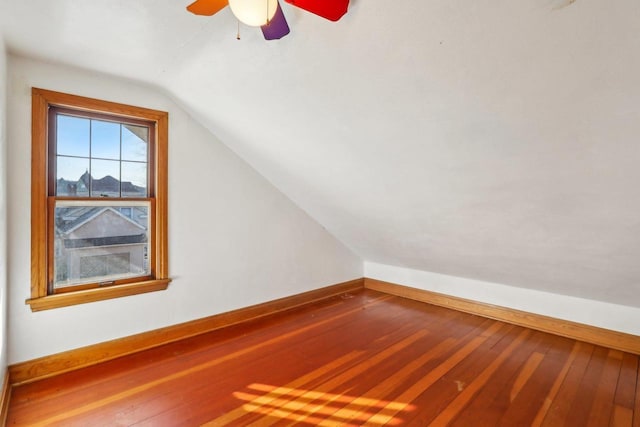 additional living space featuring lofted ceiling, hardwood / wood-style flooring, baseboards, and ceiling fan