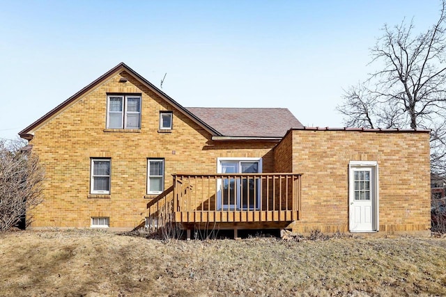 back of house with brick siding and a wooden deck