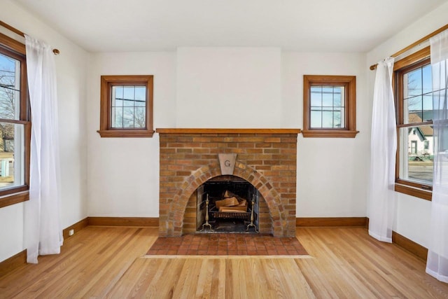 unfurnished living room with a fireplace, wood finished floors, and baseboards