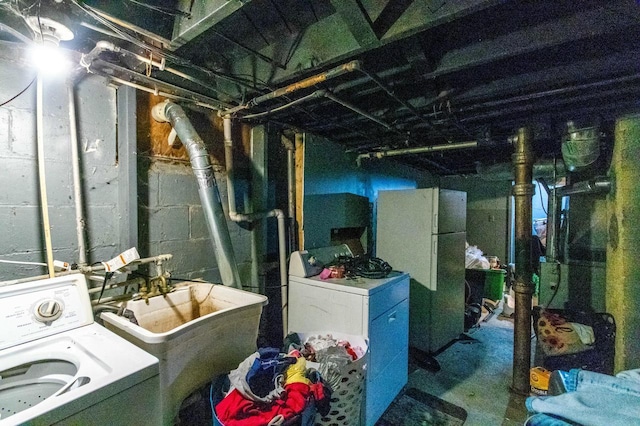 unfinished below grade area featuring washer / dryer, freestanding refrigerator, and a sink