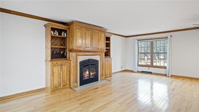 unfurnished living room featuring a warm lit fireplace, ornamental molding, light wood-style flooring, and baseboards