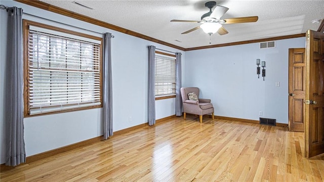 sitting room featuring light wood-style floors, visible vents, and ornamental molding