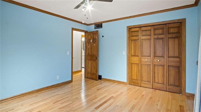 unfurnished bedroom with baseboards, light wood-type flooring, visible vents, and crown molding