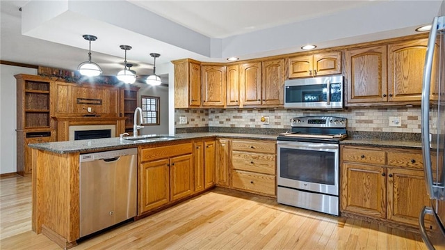 kitchen with stainless steel appliances, a sink, and brown cabinets