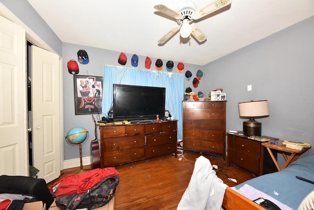 bedroom featuring baseboards, a ceiling fan, and wood finished floors