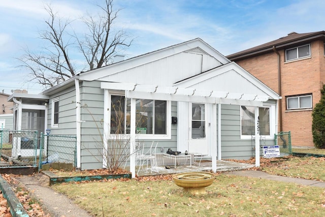 bungalow-style house with board and batten siding and fence