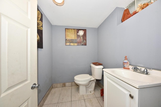 half bath with baseboards, vanity, and toilet