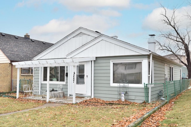 view of front of house with a patio, a shingled roof, fence, and a pergola