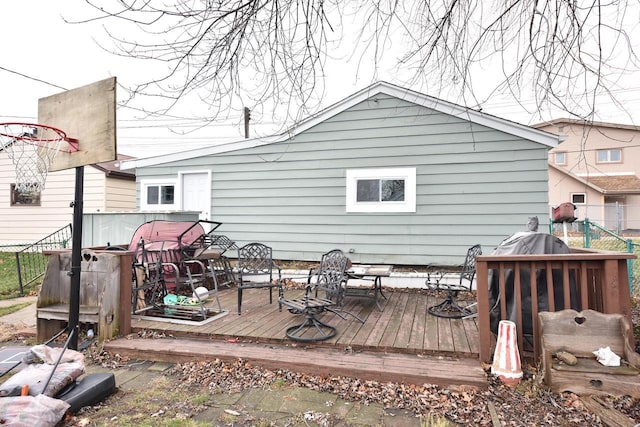 rear view of house with fence and a deck