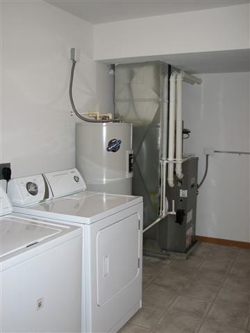 washroom featuring washing machine and dryer, laundry area, and electric water heater