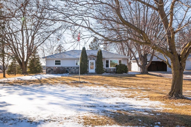 view of front of home with stone siding, metal roof, and an outdoor structure