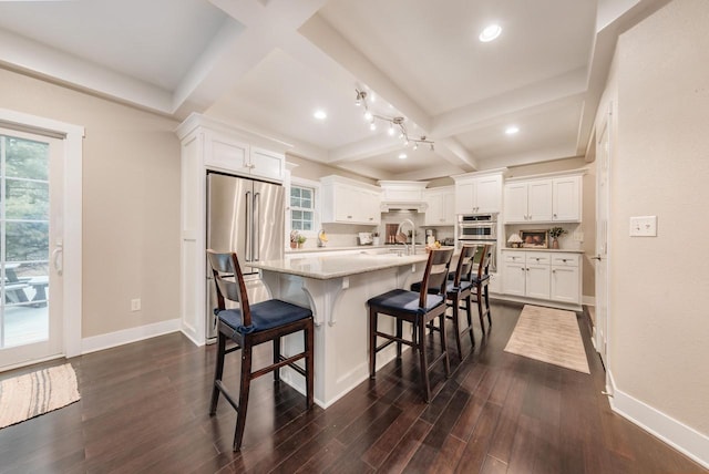 kitchen with baseboards, white cabinets, coffered ceiling, appliances with stainless steel finishes, and dark wood-style flooring