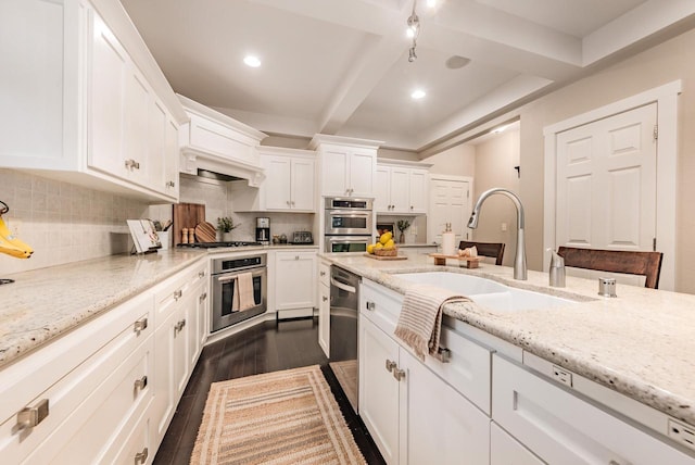 kitchen featuring stainless steel appliances, backsplash, a sink, and dark wood finished floors