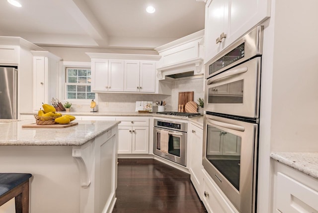 kitchen featuring white cabinets, dark wood-style floors, stainless steel appliances, and decorative backsplash