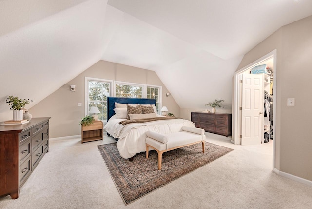 bedroom featuring lofted ceiling, light colored carpet, and baseboards